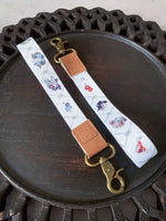 Load image into Gallery viewer, White Skulls and Flowers Wrist Lanyard
